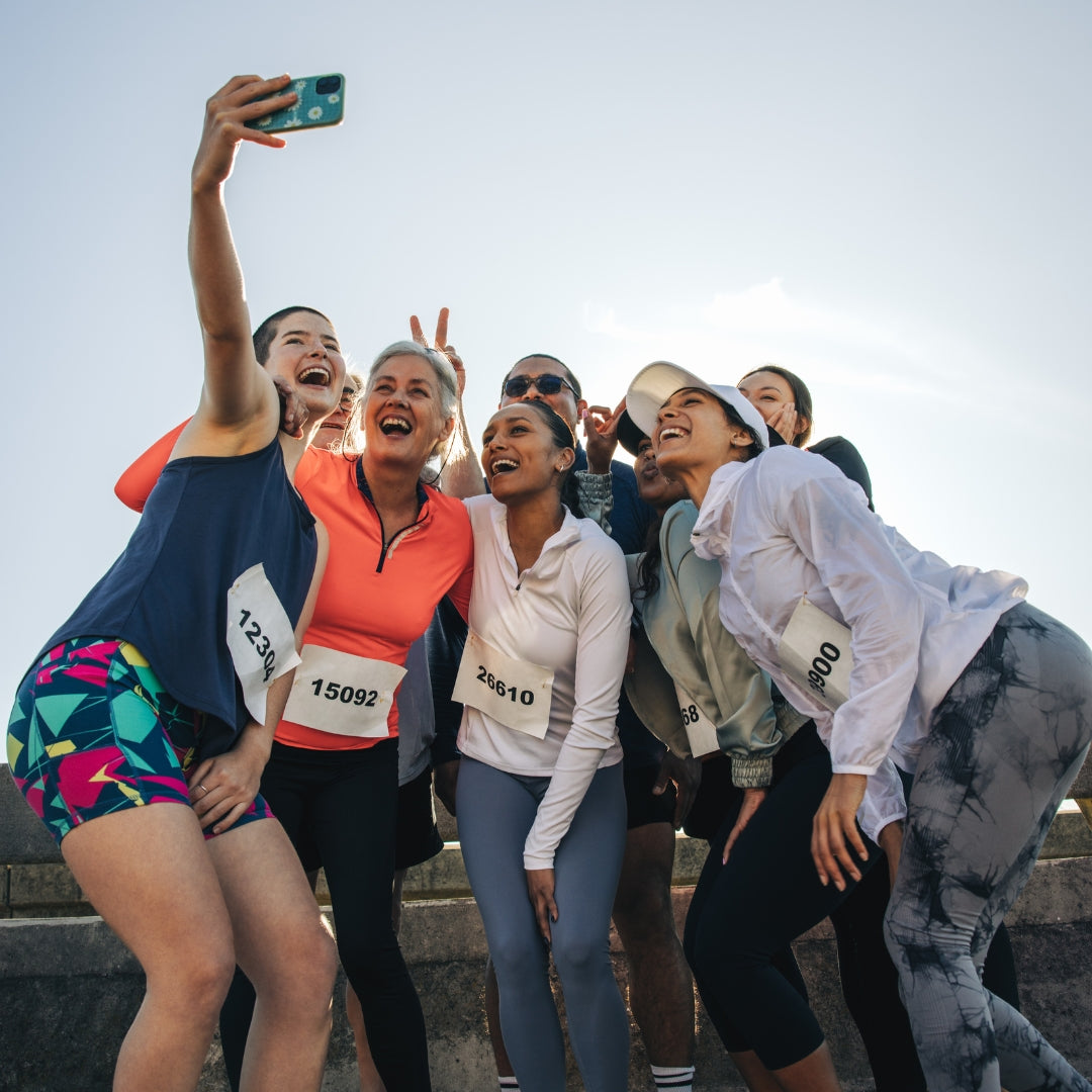Group of runners taking a selfie outdoors on a clear day